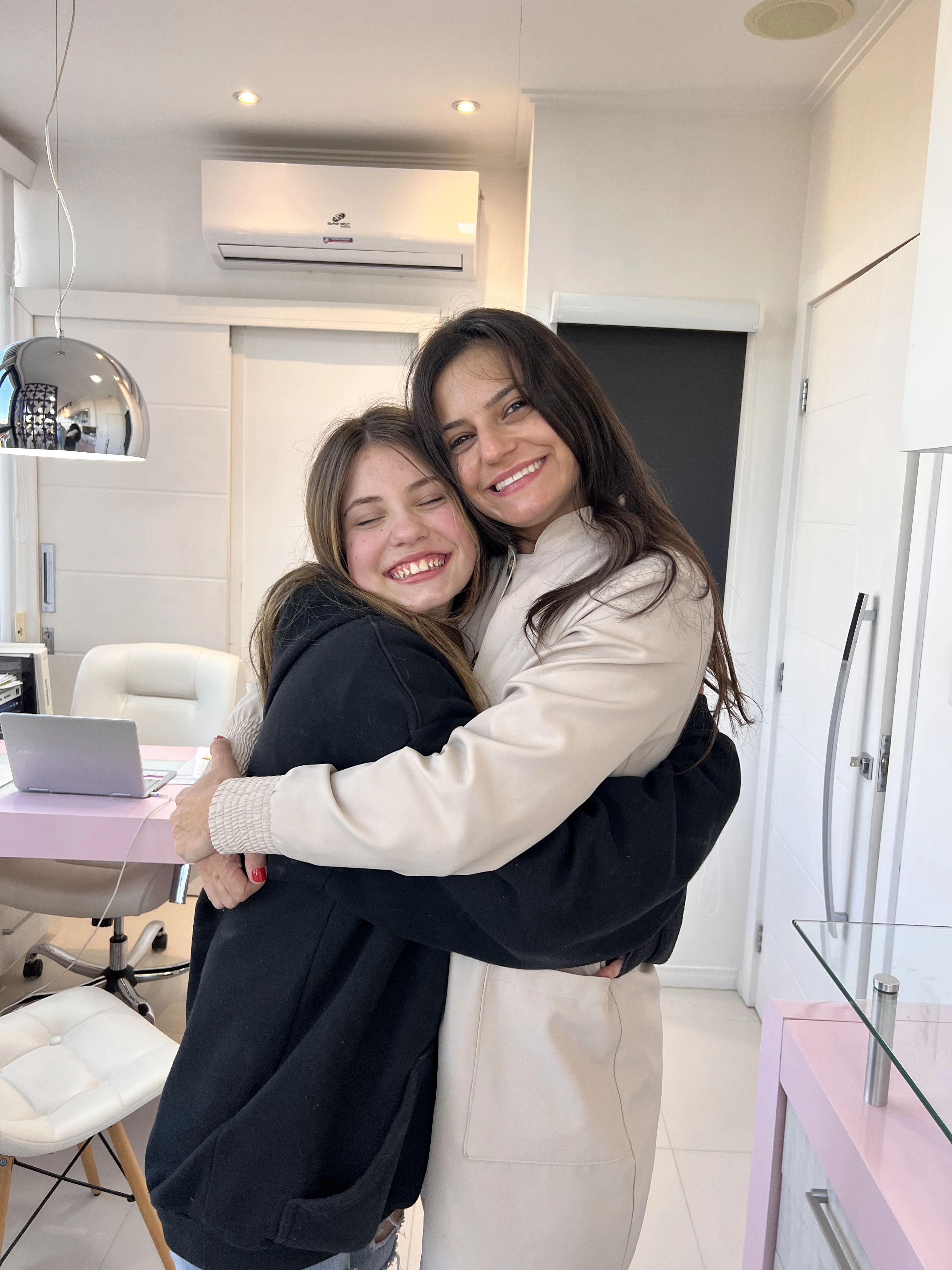 Paciente jovem abraçando a dentista após tratamento